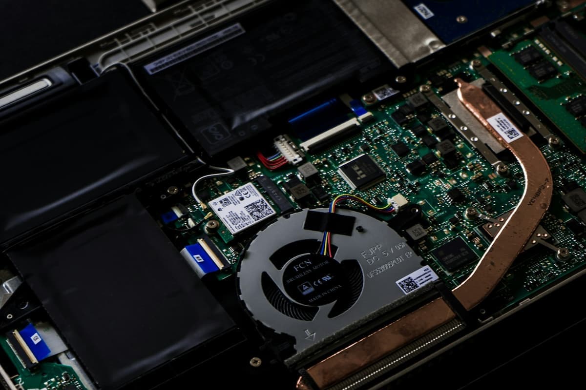 An opened laptop chassis showing the mainboard, memory, storage drive and cooling assembly